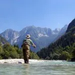A man fishing on the Soča River
